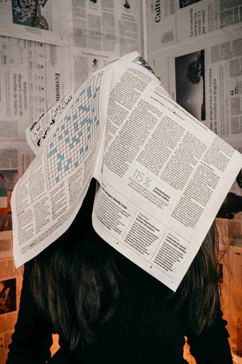 Lady with newspaper over her head
